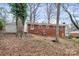 View of the home's backyard, featuring a red brick exterior, storage shed and a parked trailer at 1418 Nottingham Rd, Kannapolis, NC 28081
