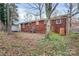View of the home's backyard, featuring a red brick exterior and storage shed at 1418 Nottingham Rd, Kannapolis, NC 28081