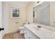 Bright bathroom with a large mirror, white vanity, and a window providing natural light at 1418 Nottingham Rd, Kannapolis, NC 28081