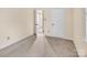 A carpeted room with cream walls, a white door, and a hallway leading to a bathroom at 1418 Nottingham Rd, Kannapolis, NC 28081
