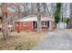 Inviting brick home with covered porch, storage shed, and paved driveway at 1418 Nottingham Rd, Kannapolis, NC 28081