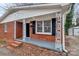 Inviting brick home entrance with decorative columns, black shutters, and a freshly painted porch at 1418 Nottingham Rd, Kannapolis, NC 28081