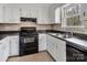 This kitchen features white cabinets, neutral countertops, and modern appliances at 1418 Nottingham Rd, Kannapolis, NC 28081