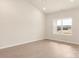Bright bedroom with neutral walls and carpeting, featuring a large window at 150 Adams Tree Way, Troutman, NC 28166