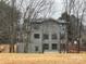 View of multi-story home amongst bare trees, showcasing its architectural design and placement on the property at 150 Driftwood Dr, Mooresville, NC 28117