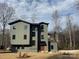 Striking modern architecture with a unique balcony, set against a natural landscape and blue skies at 150 Driftwood Dr, Mooresville, NC 28117