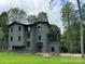 Stylish two-story home with gray siding and a unique cantilevered design; well-manicured lawn at 150 Driftwood Dr, Mooresville, NC 28117