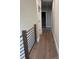 This image showcases a hallway with hardwood flooring and an iron railing at 150 Driftwood Dr, Mooresville, NC 28117