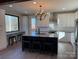 Spacious kitchen featuring an island with seating, white cabinetry, modern lighting and scenic views at 150 Driftwood Dr, Mooresville, NC 28117