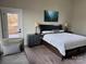 Comfortable main bedroom featuring a seating area, hardwood floors, and deck access at 150 Driftwood Dr, Mooresville, NC 28117