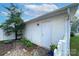 Garage exterior with a white door, small palm tree, rock groundcover and potted plants at 156 Singleton Rd, Mooresville, NC 28117