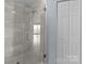Walk-in shower features glass door and tile surround; view into bedroom at 17931 Kings Point Dr # G, Cornelius, NC 28031