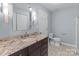 Bathroom featuring granite countertops, single sink vanity, and decorative sconces at 17931 Kings Point Dr # G, Cornelius, NC 28031