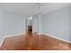 Spacious bedroom with hardwood floors, neutral paint, and a ceiling fan; bathroom access at 17931 Kings Point Dr # G, Cornelius, NC 28031
