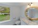 Bathroom with updated vanity, round mirror, and a window with a view at 2085 Faith Rd, Salisbury, NC 28146