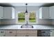 Modern kitchen with white cabinets, granite countertops and a large window overlooking the backyard at 2085 Faith Rd, Salisbury, NC 28146