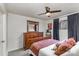 Comfortable bedroom features wood dresser, ceiling fan, large window and carpeting at 421 N Church St # 12F, Charlotte, NC 28202
