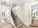 Light and bright staircase with wood steps and black metal railing at 5053 Townsend Rd, Lancaster, SC 29720