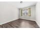 Simple bedroom with wood floors and a window with blinds at 7617 Red Robin Trl, Denver, NC 28037