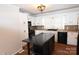 White kitchen with black countertops, island, and hardwood floors at 9 N 11Th Ave, Maiden, NC 28650