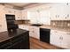 Bright kitchen with white cabinets, black appliances, and an island at 9 N 11Th Ave, Maiden, NC 28650