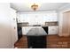 White kitchen with black countertops, island, and hardwood floors at 9 N 11Th Ave, Maiden, NC 28650