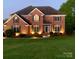 Brick two-story house with landscaped lawn and lighting at 104 Fox Den Cir, Statesville, NC 28677