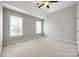 Bedroom with neutral walls, carpet, and two windows at 11622 Morgan Horse Trl, Huntersville, NC 28078