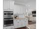 White kitchen cabinets, double ovens, granite counters and open to Gathering room at 2262 Sweet Pea Ln, Harrisburg, NC 28075