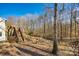 Large backyard with wooden deck, stairs and a tree-filled backdrop at 2702 Oxborough Dr, Matthews, NC 28105