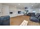 Finished basement recreation room with built-in shelving, leather seating, and hardwood floors at 2702 Oxborough Dr, Matthews, NC 28105