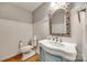 Elegant bathroom with a pedestal sink, decorative mirror, and wainscoting at 2702 Oxborough Dr, Matthews, NC 28105