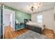 Cozy bedroom with a gray bed, built-in desk, and green accent wall at 2702 Oxborough Dr, Matthews, NC 28105