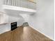 Open living room area with fireplace, hardwood floors, and stairway to loft at 4818 Whistling Oak Ct, Charlotte, NC 28269