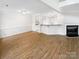 Open floor plan with hardwood floors connecting the living room, kitchen, and breakfast bar at 4818 Whistling Oak Ct, Charlotte, NC 28269
