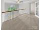 Loft area featuring a railing overlooking the living space, carpet, and natural light at 4818 Whistling Oak Ct, Charlotte, NC 28269