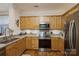 Modern kitchen with stainless steel appliances and light wood cabinets at 5998 Village Nw Dr, Concord, NC 28027