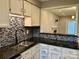 Kitchen features a dark countertop, double sink, and blue mosaic backsplash at 6130 Heath Ridge Ct, Charlotte, NC 28210