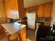 Kitchen with wood cabinets, white appliances, and a corner breakfast bar at 9915 Washam Potts Rd, Cornelius, NC 28031