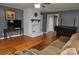 Living room with hardwood floors, white fireplace and a large TV at 109 Shamrock Dr, Chester, SC 29706