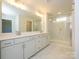 Bright bathroom featuring double vanity, quartz counters, and glass-enclosed shower with marble-patterned tile at 119 Quartz Hill Way, Waxhaw, NC 28173