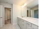 Bright bathroom featuring double vanity with quartz counters, tile floor, and adjacent walk-in closet at 119 Quartz Hill Way, Waxhaw, NC 28173
