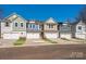 New townhome exteriors showcase varied colors, two-car garages, and landscaping at 119 Quartz Hill Way, Waxhaw, NC 28173