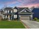 Beautiful home with manicured lawn, inviting porch and a two-car garage against a colorful sunset backdrop at 1224 Regions Blvd, Fort Mill, SC 29707