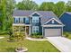 Lovely two-story home featuring a charming front porch, landscaped yard, and an attached two-car garage at 1224 Regions Blvd, Fort Mill, SC 29707