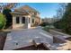 A backyard stone patio with landscaping and a seating area is the perfect space for entertaining at 15618 Frohock Pl, Charlotte, NC 28277