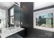 Stylish bathroom with dark gray walls, a modern vanity, and a window providing natural light at 15618 Frohock Pl, Charlotte, NC 28277