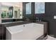 Stylish bathroom featuring a soaking tub, dark tile accents, and contemporary design at 15618 Frohock Pl, Charlotte, NC 28277