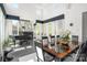 View of the dining room with a large table, piano, and lots of natural light from the big windows at 15618 Frohock Pl, Charlotte, NC 28277