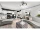 Bright living room featuring a modern sofa, ceiling fan, and open layout to the kitchen at 15618 Frohock Pl, Charlotte, NC 28277